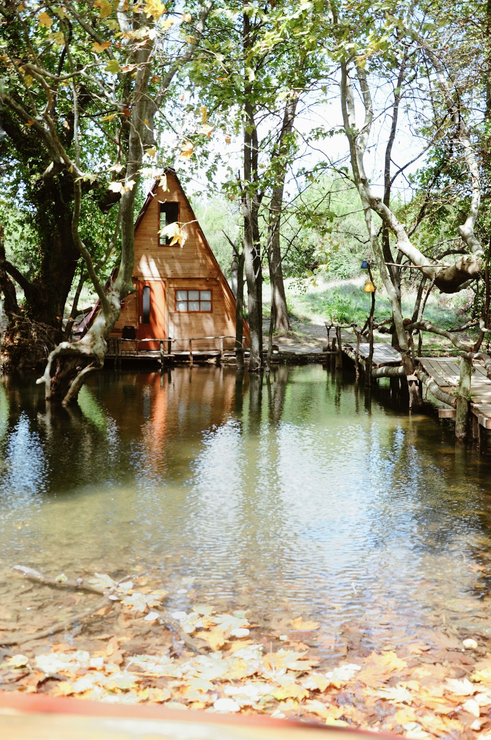 casa de madeira marrom na margem do rio durante o dia