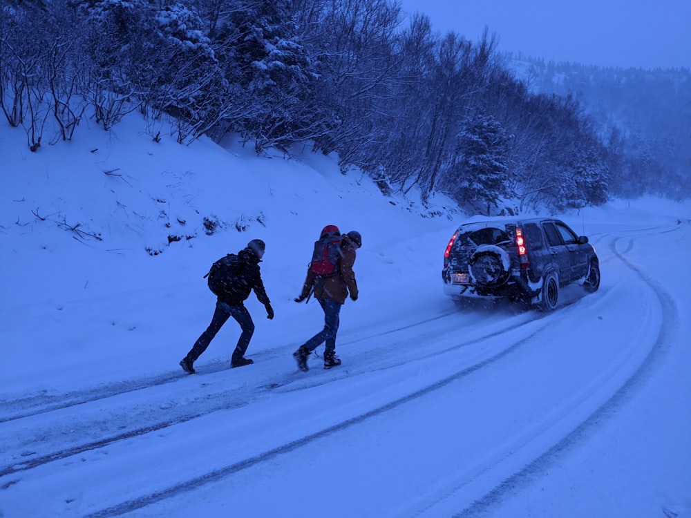 2 men walking on snow covered ground during daytime