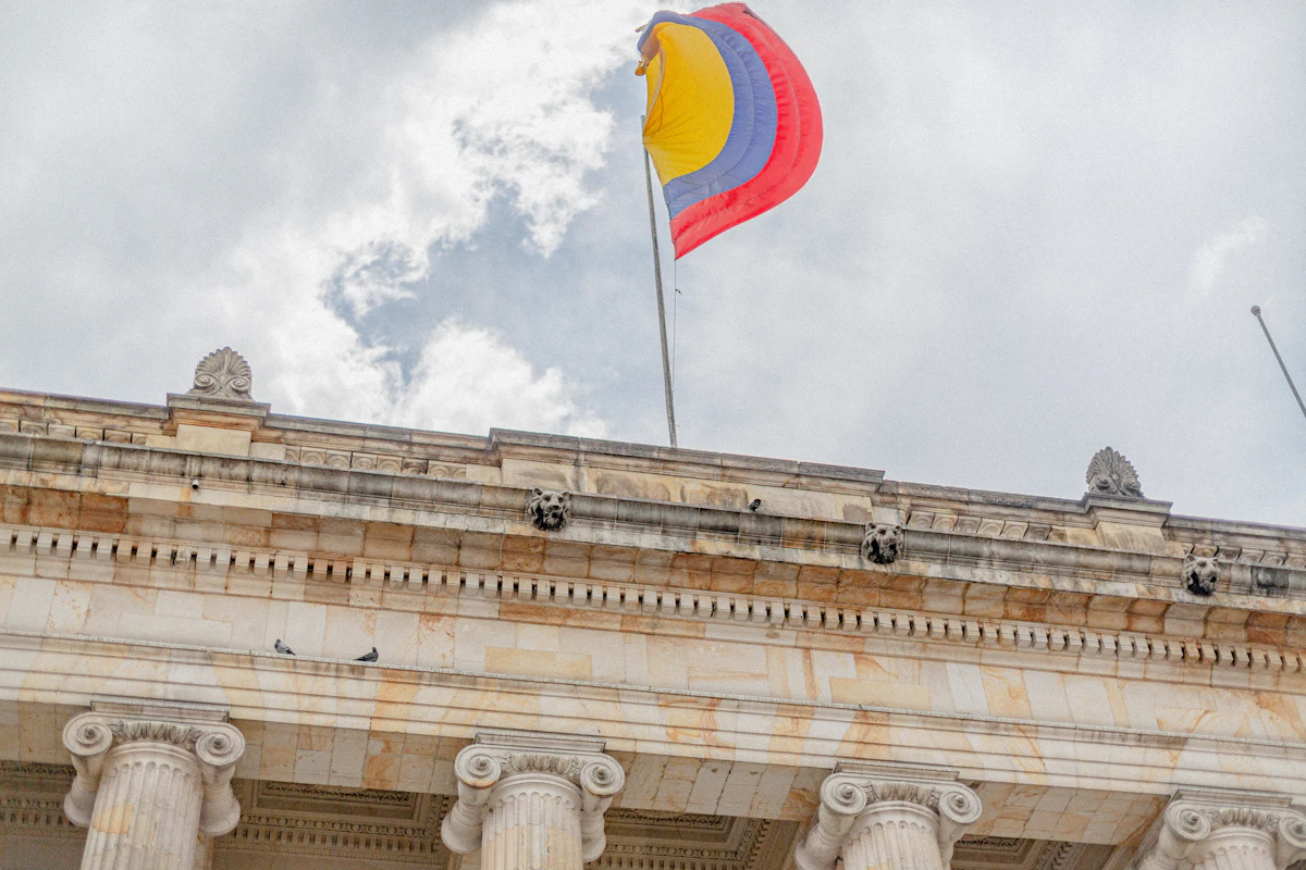 Bandera de Colombia sobre un edificio institucional de arquitectura neoclásica