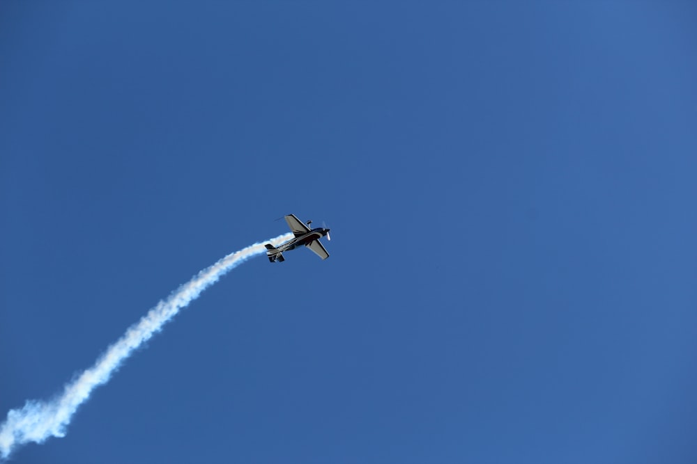 white airplane in mid air during daytime