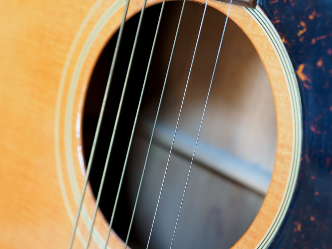 brown acoustic guitar on brown wooden table