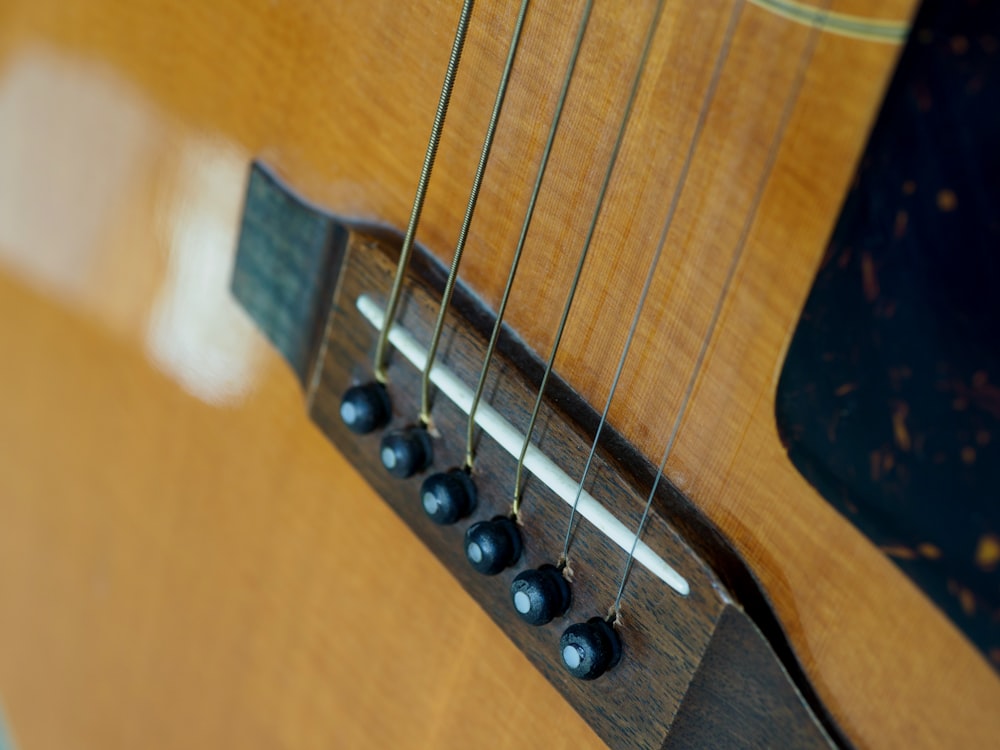 brown acoustic guitar on brown wooden table