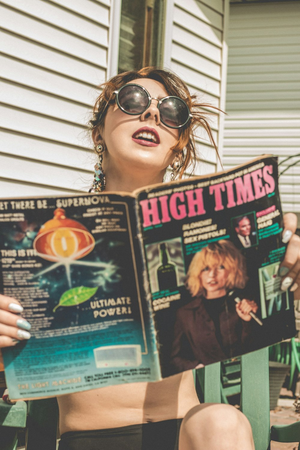 woman holding a magazine with a man in black sunglasses