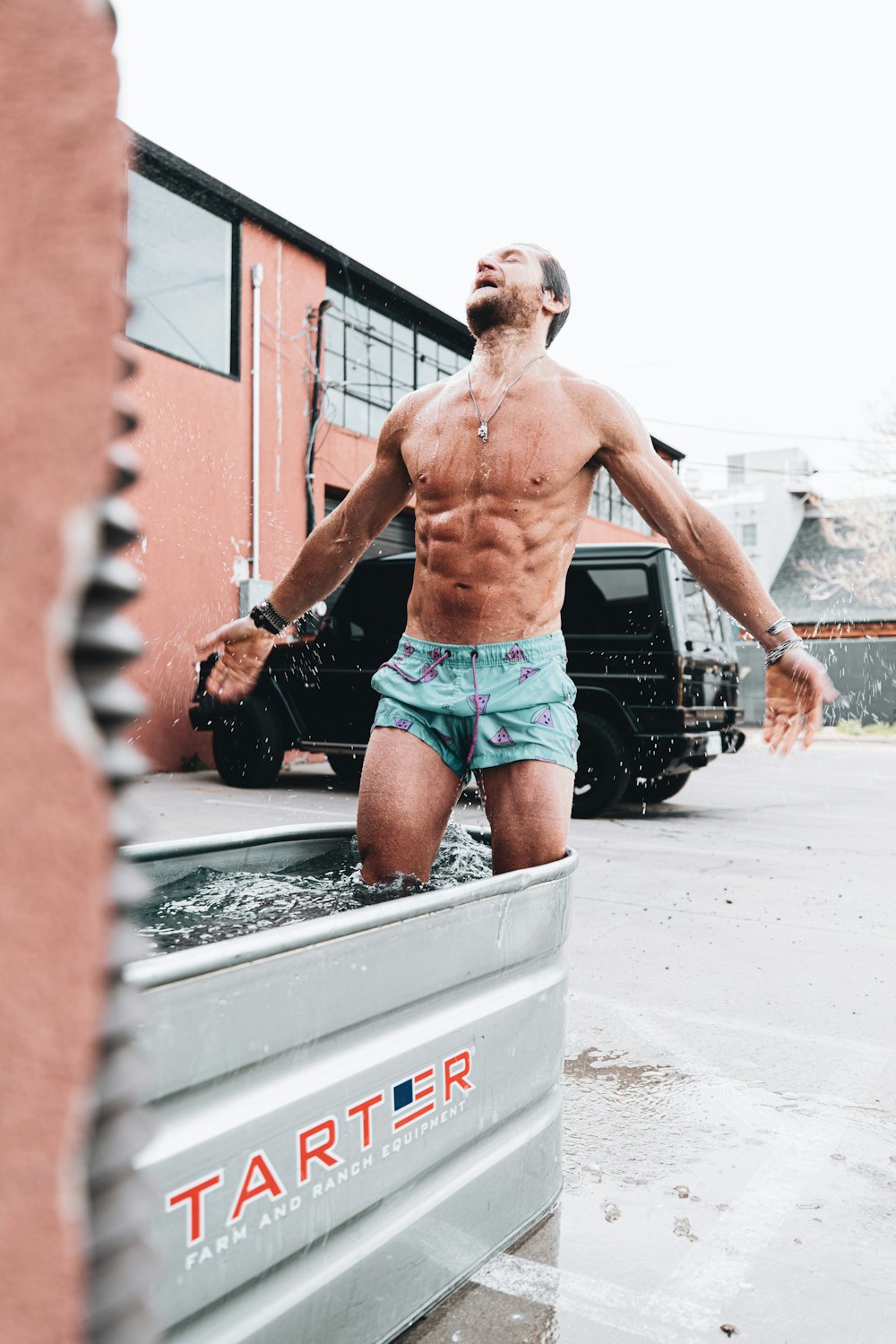 man in blue shorts standing on white concrete floor