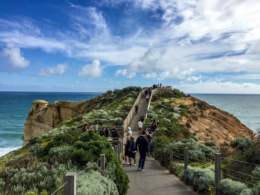 people walking on pathway near cliff during daytime