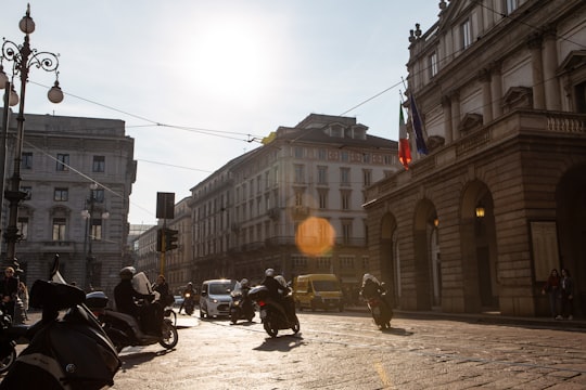 people riding motorcycle on road near buildings during daytime in Teatro alla Scala Museum Italy