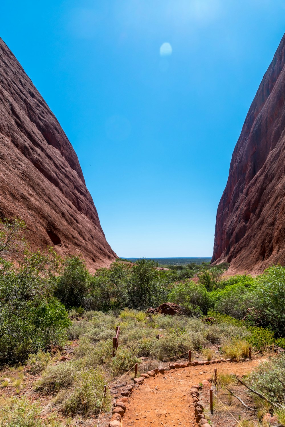 brown rock formation near green grass field during daytime