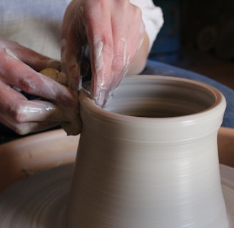 person holding brown clay pot