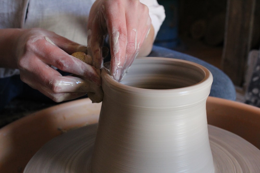 Persona che tiene un vaso di terracotta marrone