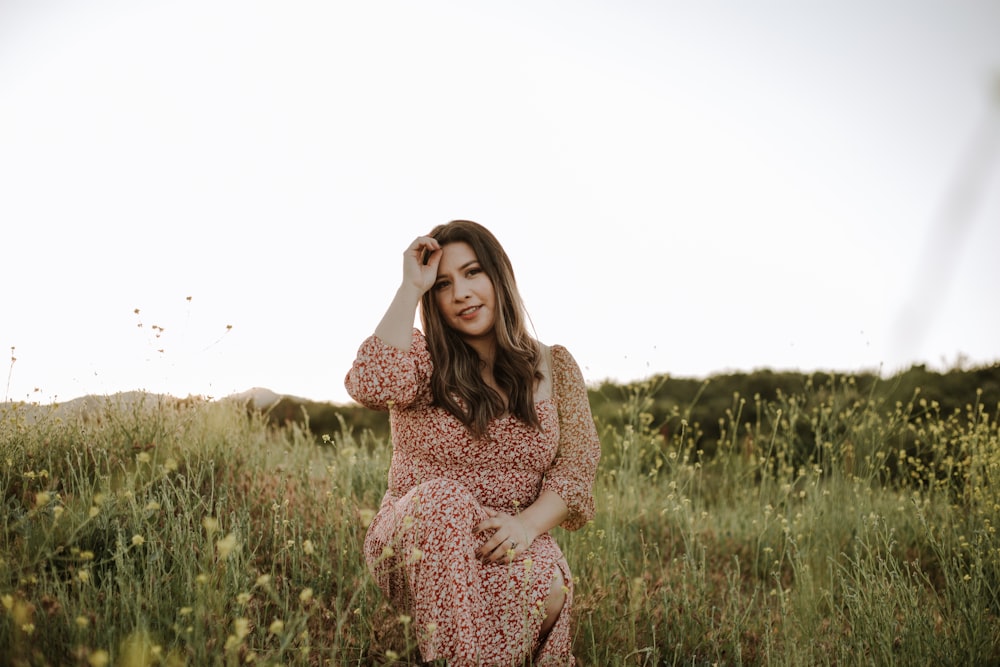 woman in brown and white long sleeve dress standing on green grass field during daytime