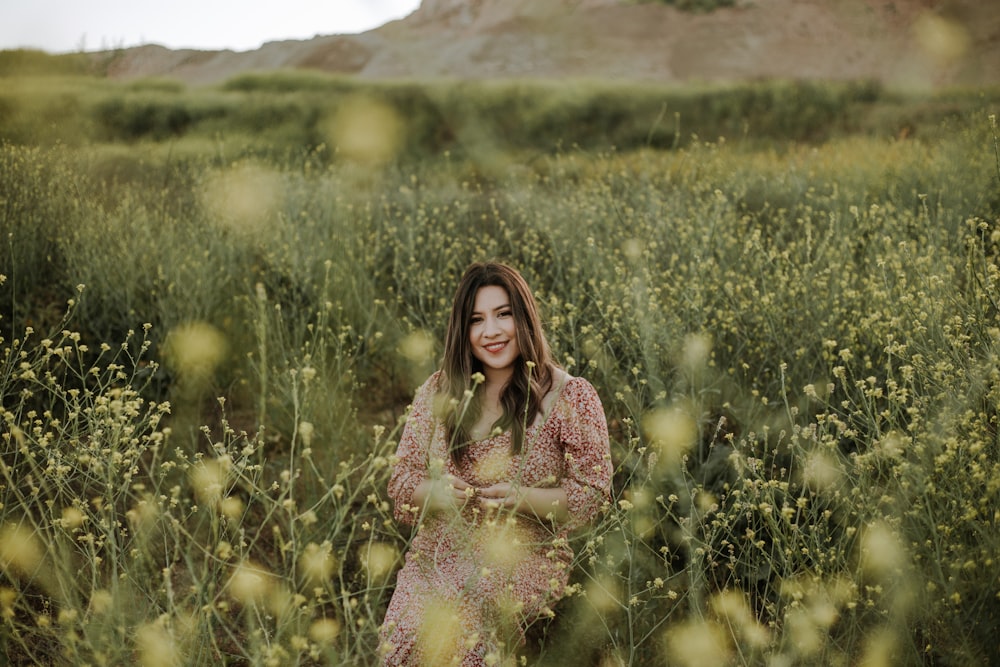 woman in blue and pink floral dress standing on green grass field during daytime