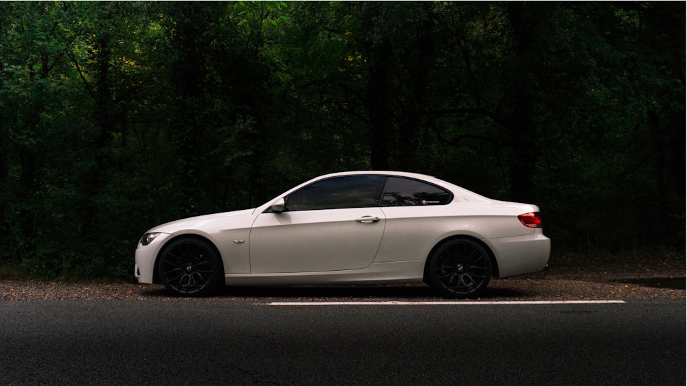 white coupe on black asphalt road