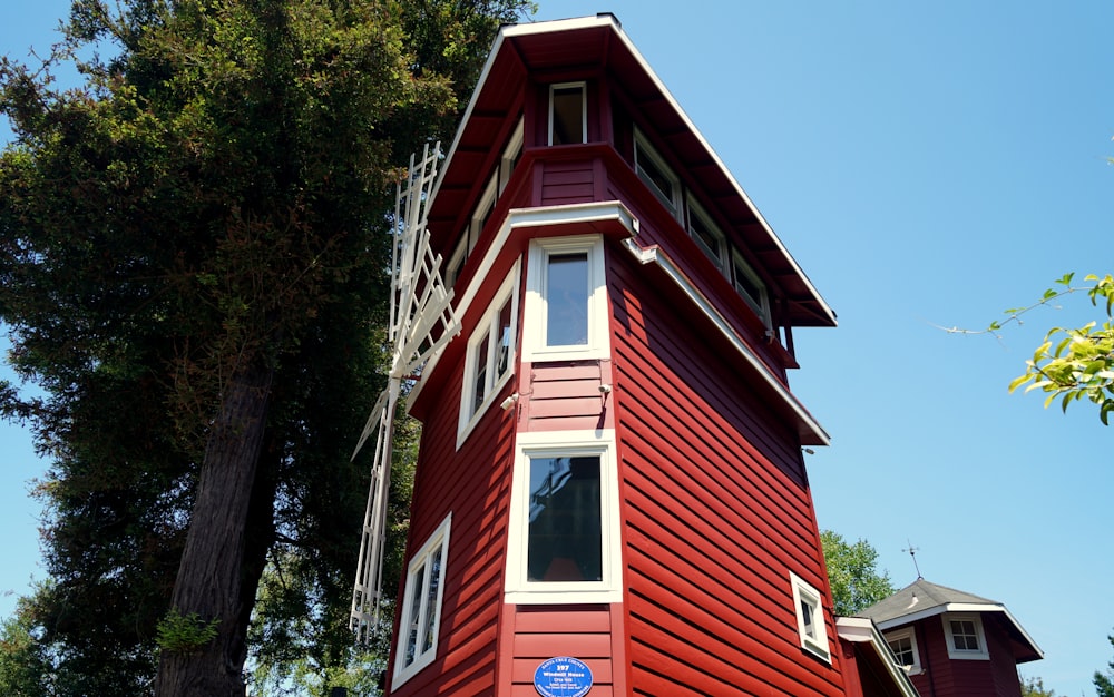 red and white wooden house near green trees during daytime