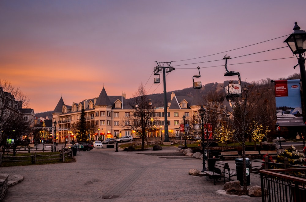 cars parked on side of the road near buildings during sunset