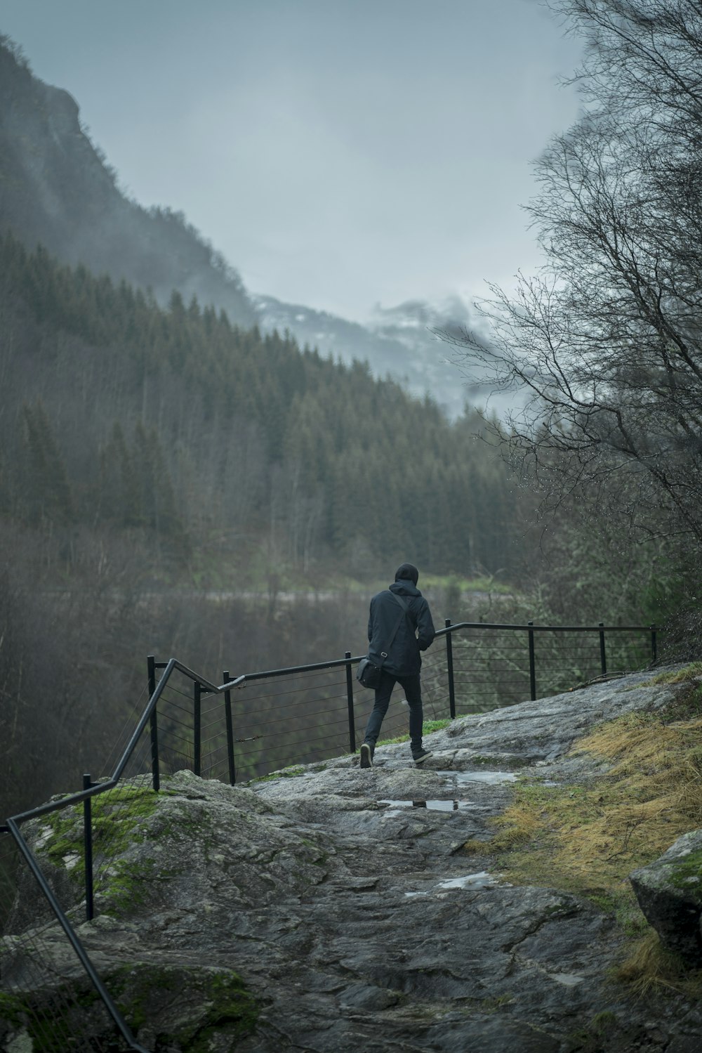 man in black jacket walking on gray rock mountain during daytime