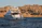 Elegant Mediterranean yacht cruising near rocky coastline under warm sunlight