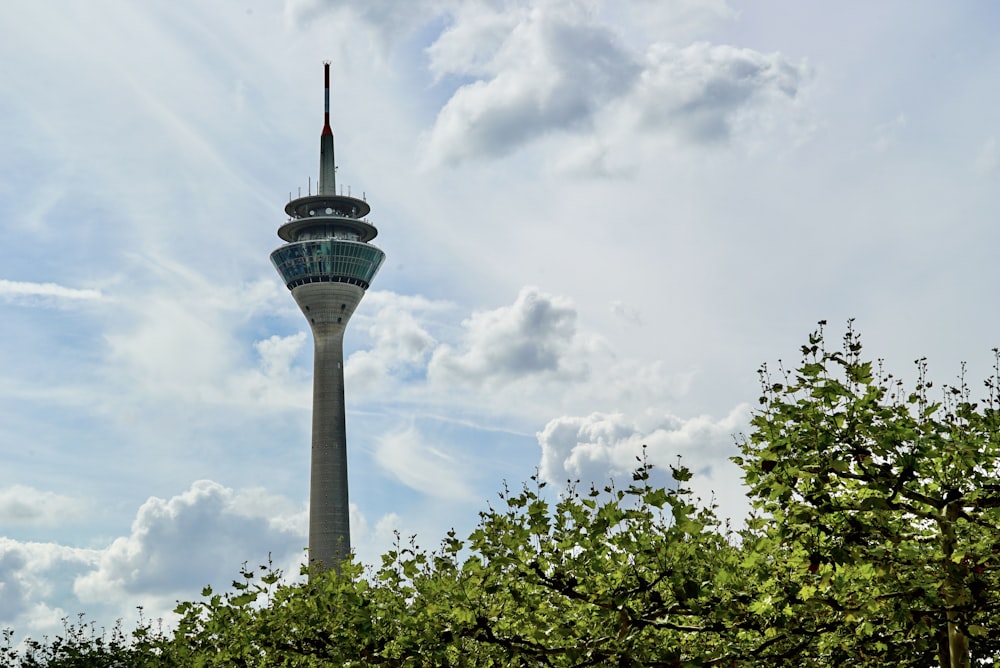 white and green concrete tower under white clouds and blue sky during daytime