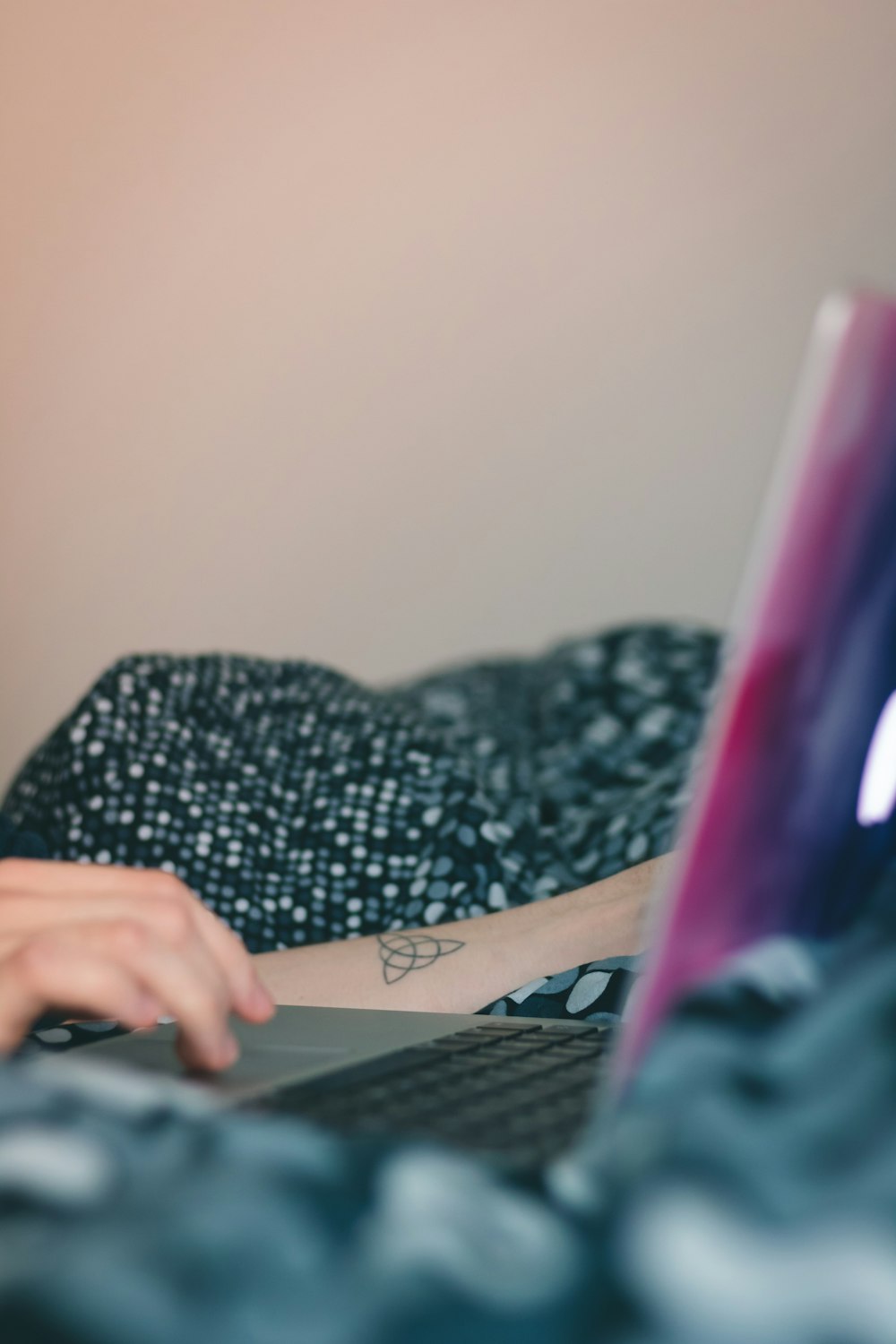 person in black and white floral long sleeve shirt using black computer keyboard