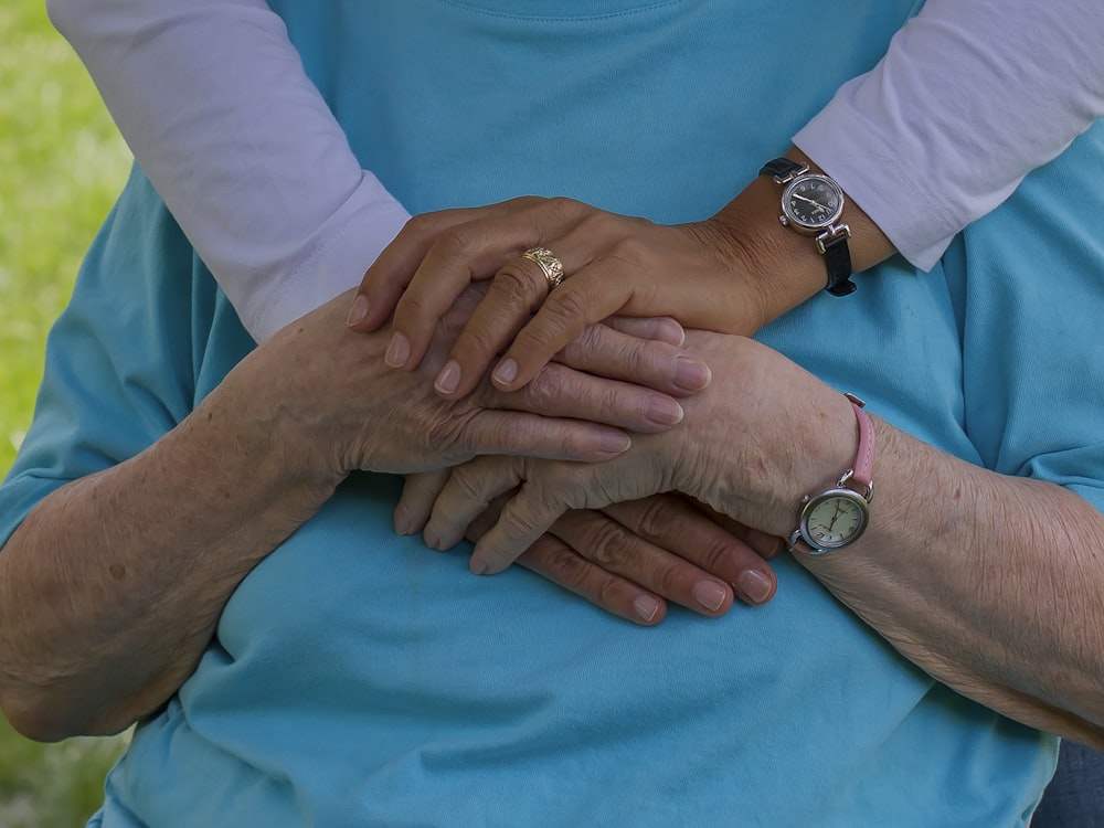 person wearing silver round analog watch