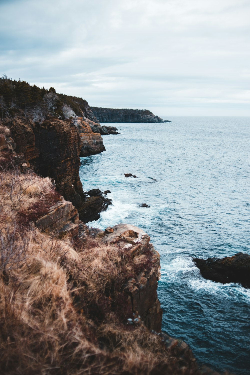 brown rock formation near body of water during daytime