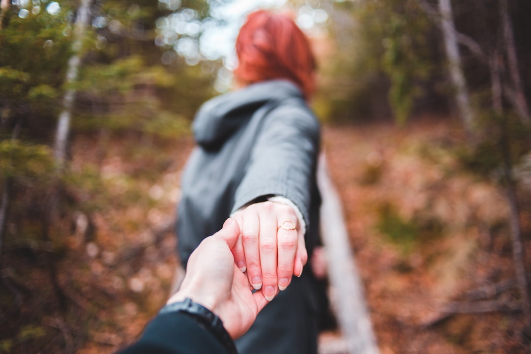 woman in black jacket holding her hand