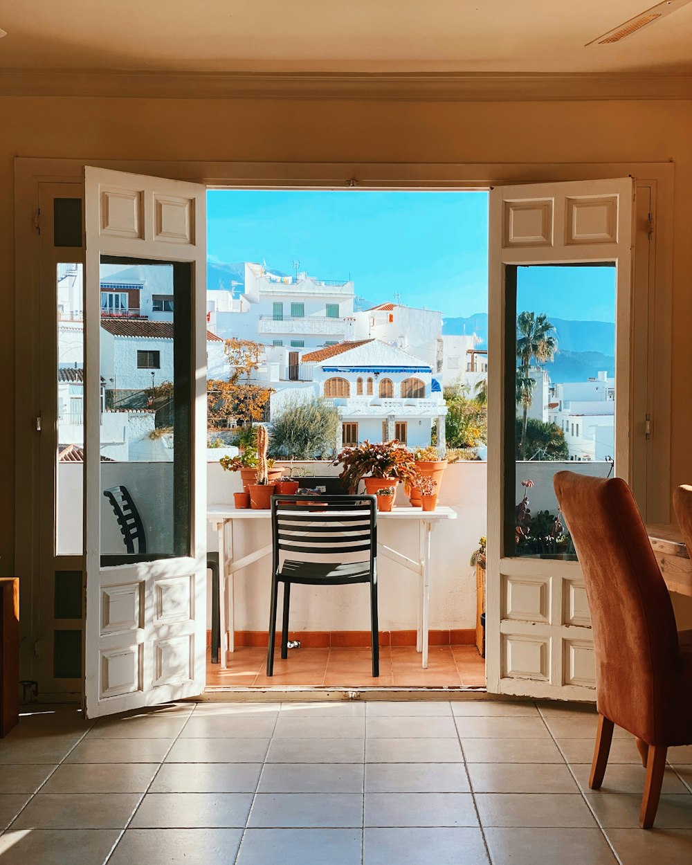 white wooden table and chairs near glass window