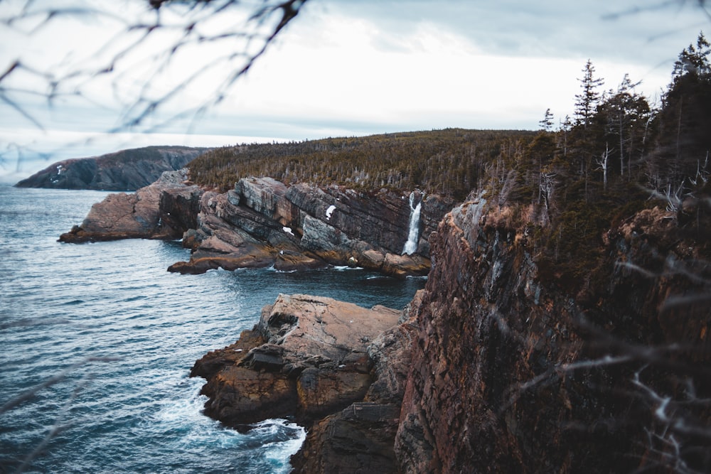 brown rock formation near body of water during daytime