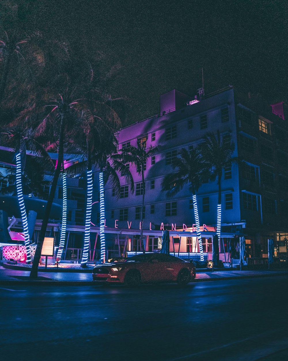 auto su strada vicino agli edifici durante la notte