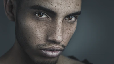 A close-up portrait of a person with expressive eyes, shot in natural light.