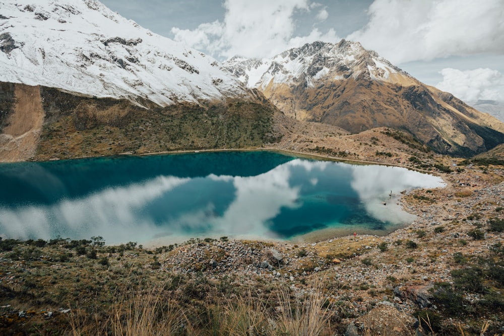 lake in the middle of snow covered mountains