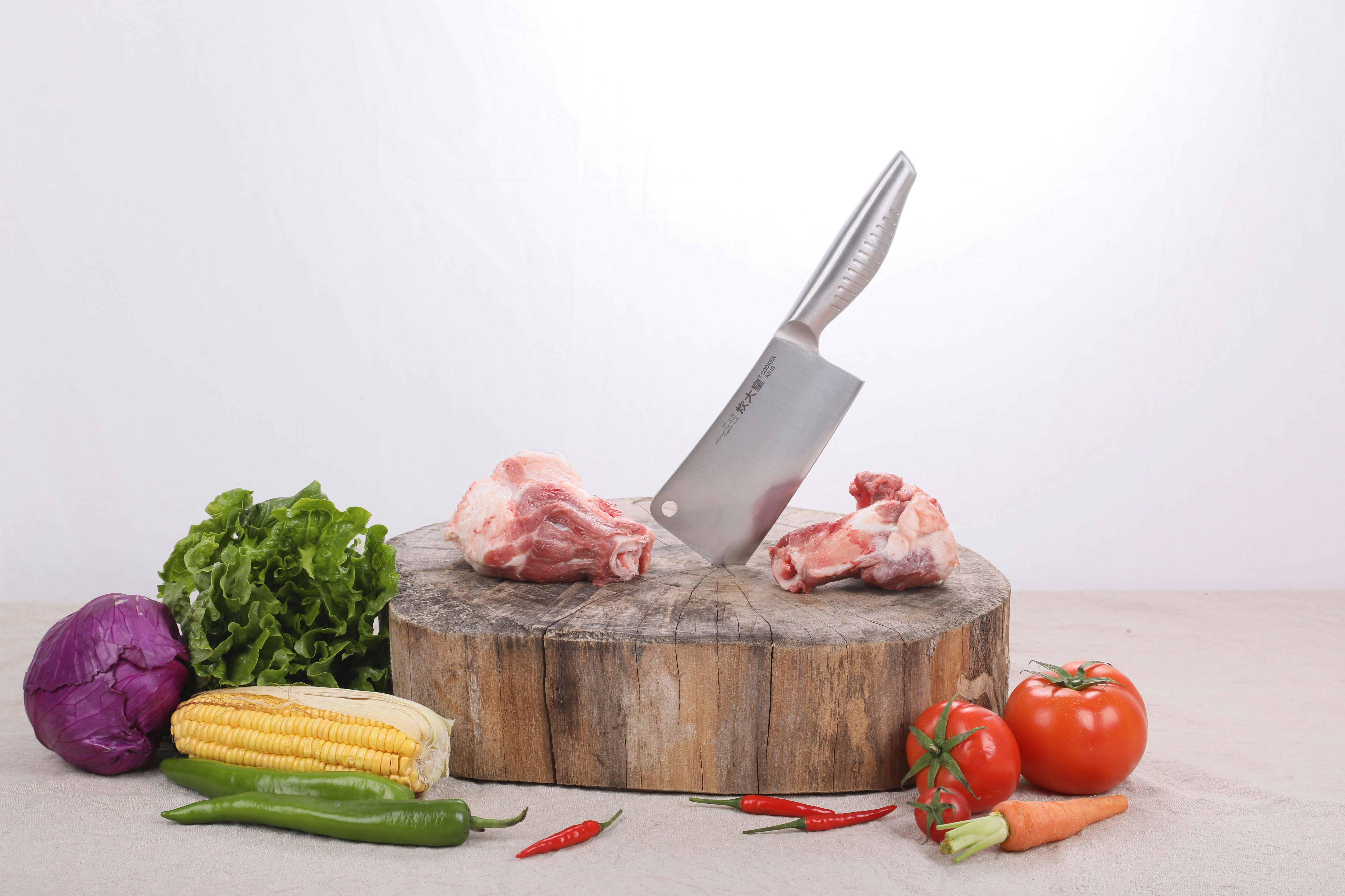 sliced meat and green vegetable on brown wooden chopping board