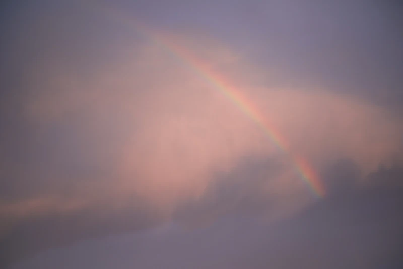 Soft pastel rainbow sky over clouds