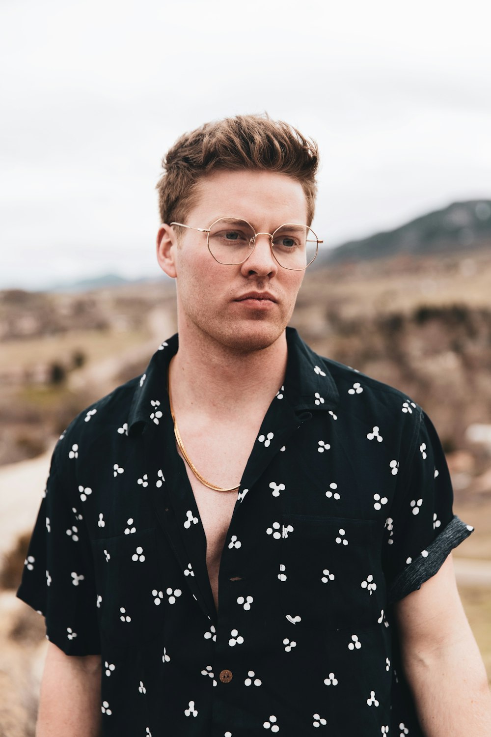 man in black and white floral button up shirt wearing eyeglasses