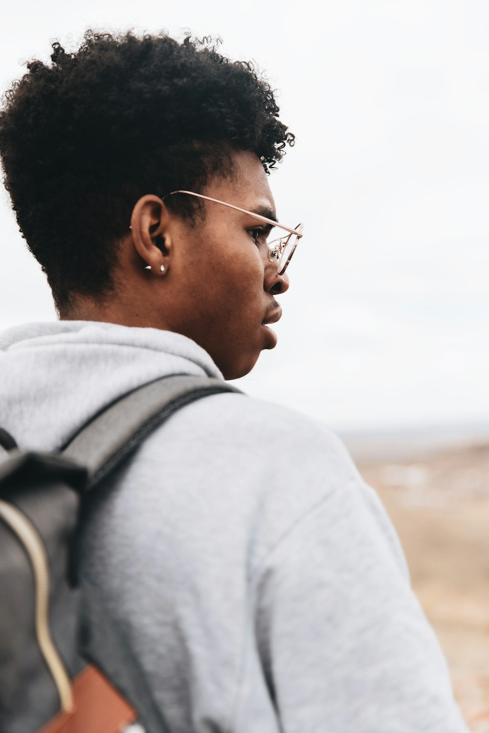 man in gray hoodie wearing silver framed aviator sunglasses