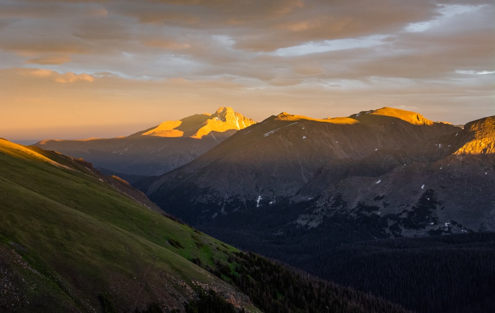 green and brown mountains under white clouds during daytime