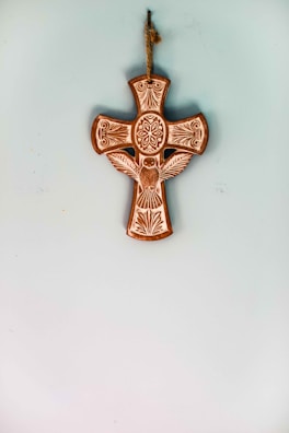 A delicate handcrafted wooden cross adorned with soft floral accents.