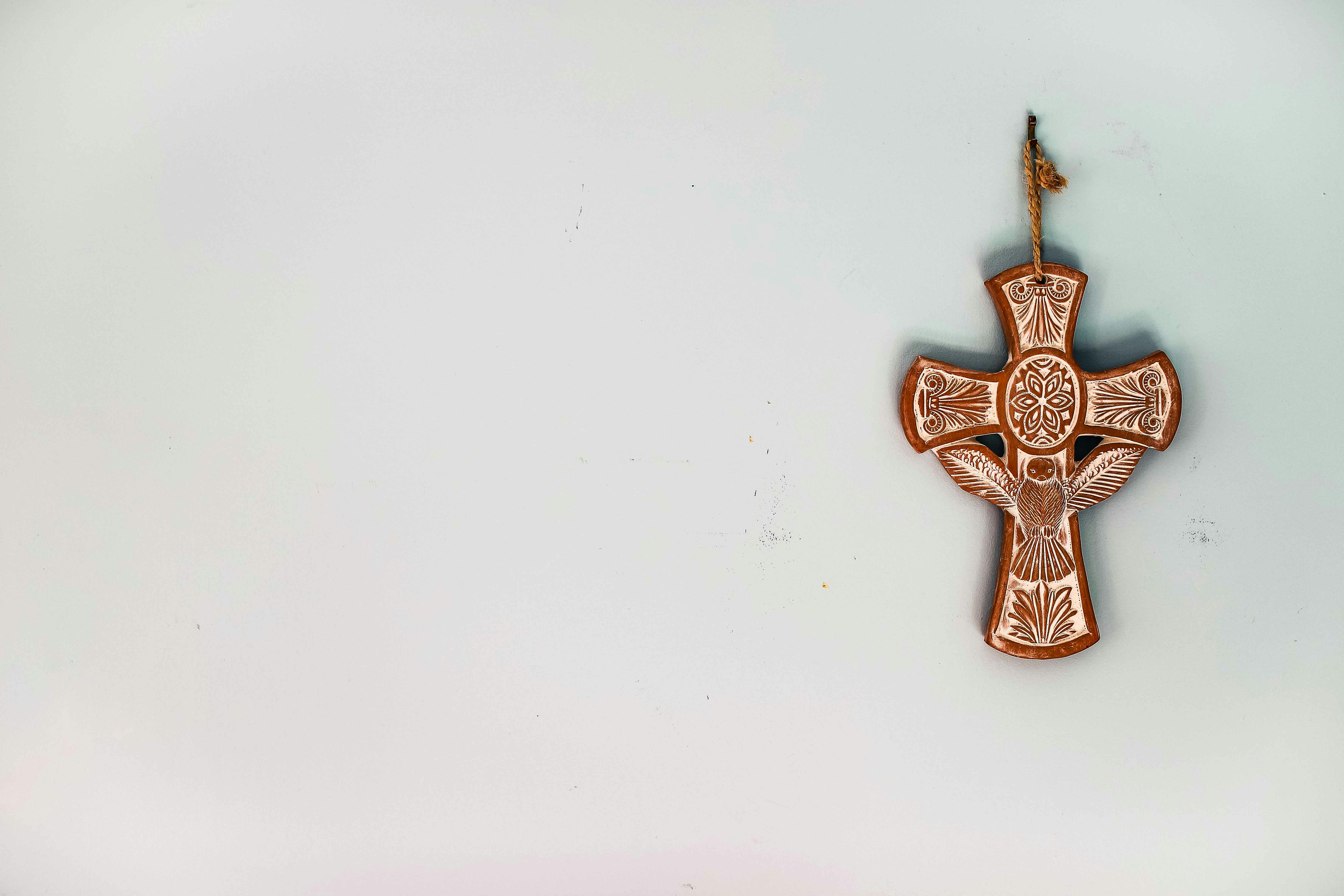 Cross on clean blue background, pottery. 