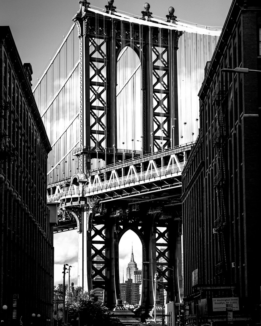 grayscale photo of bridge in between buildings