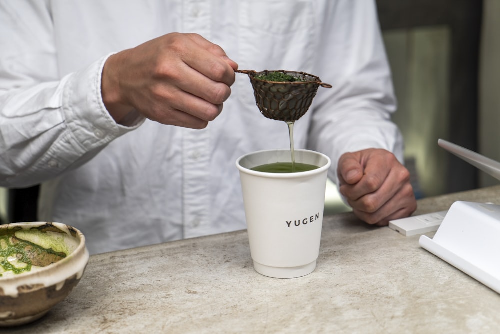 person holding green ceramic mug