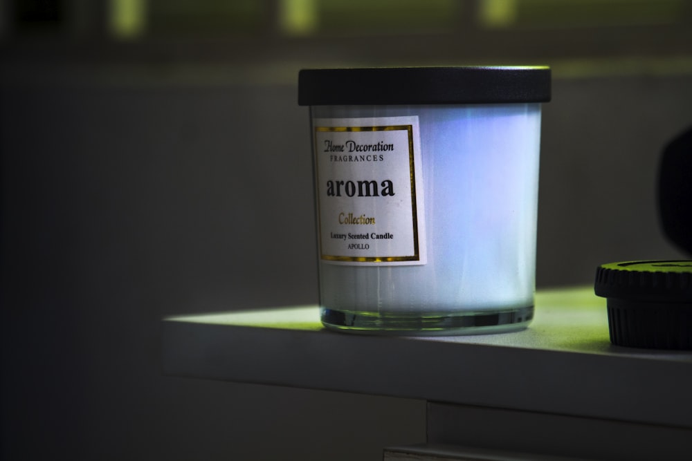 a candle sitting on top of a counter next to a container