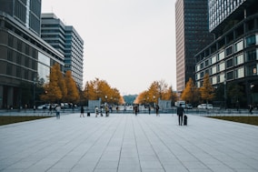 people walking on sidewalk near high rise buildings during daytime