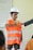boy in orange and white stripe polo shirt wearing white cap