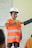 boy in orange and white stripe polo shirt wearing white cap