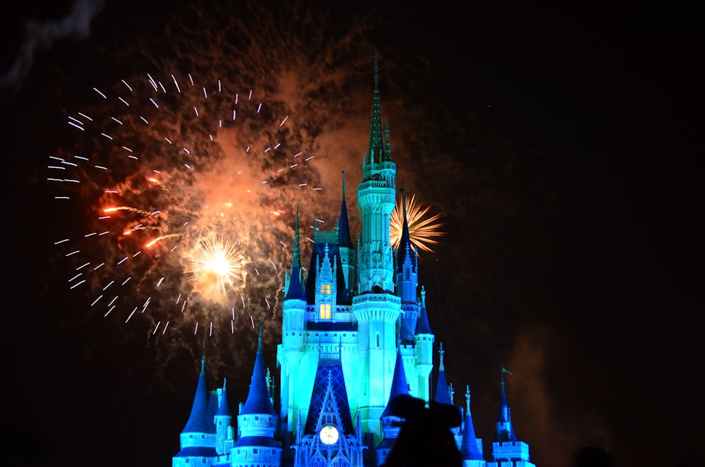 disney castle with fireworks during night time