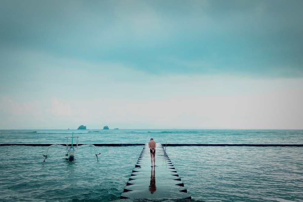 woman in white dress standing on dock during daytime