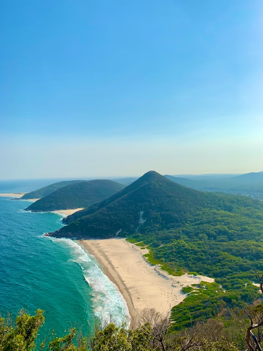 green mountain beside body of water during daytime in Tomaree National Park Australia