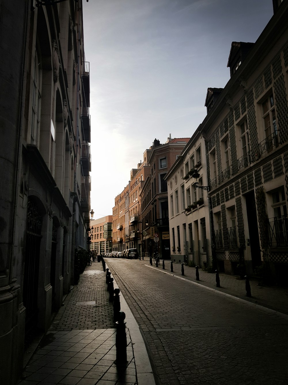 people walking on sidewalk between buildings during daytime