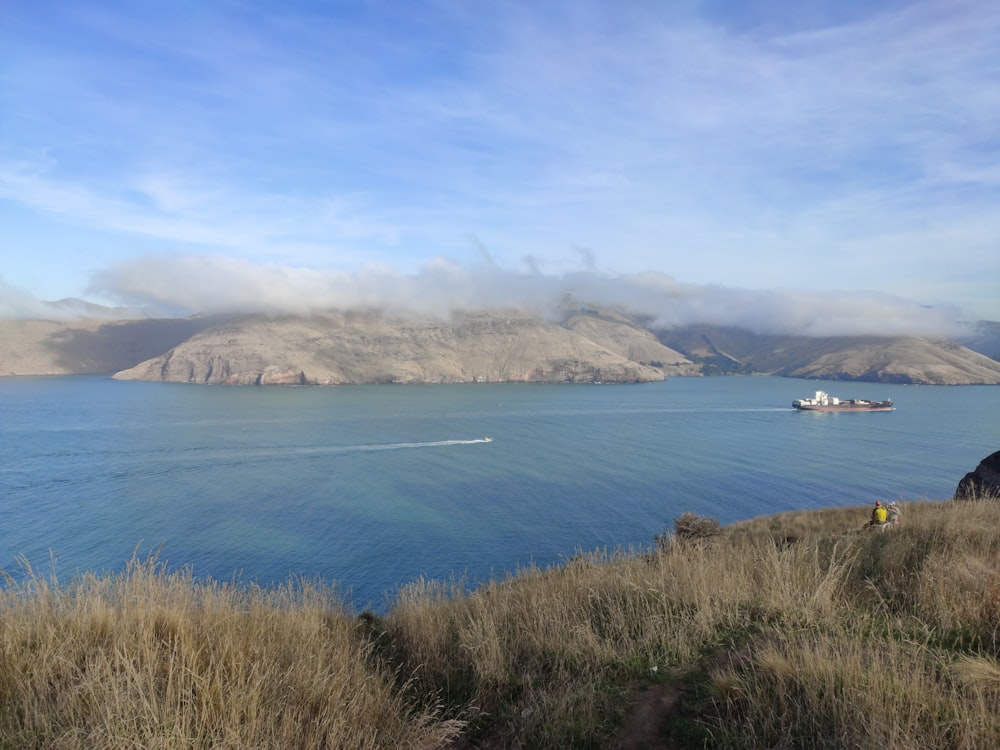 green mountain beside blue sea under blue sky during daytime