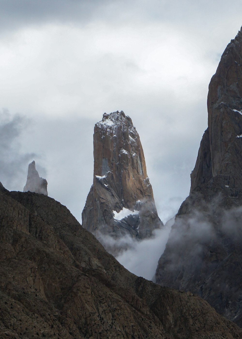 brown rocky mountain under white clouds during daytime