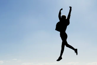 silhouette of man jumping during daytime
